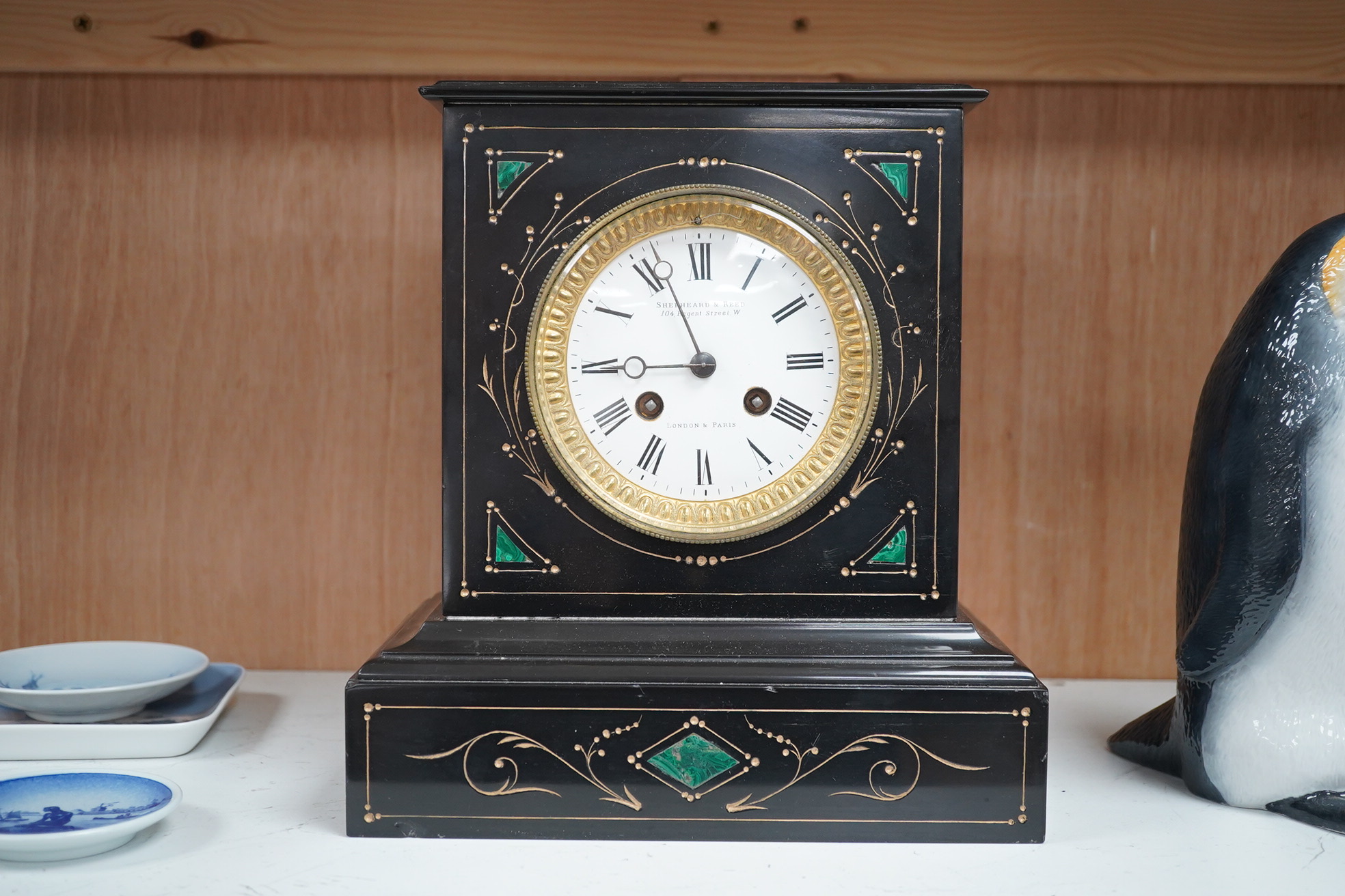 A late 19th century, French black marble eight day mantel clock, inset with malachite, retailed by Shepheard & Rees, with pendulum, no key, 26cm high. Condition - fair, minor chipping, untested